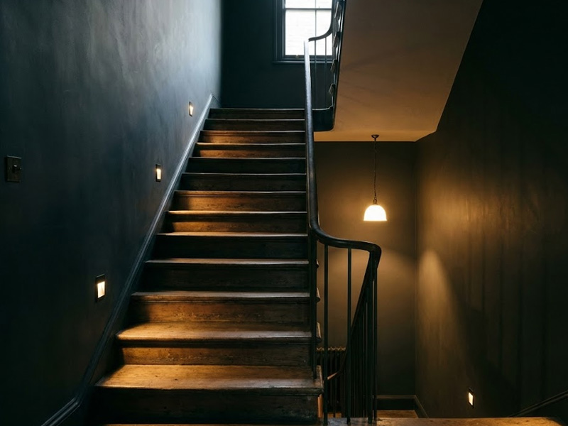 escalera interior sin iluminación natural en vivienda